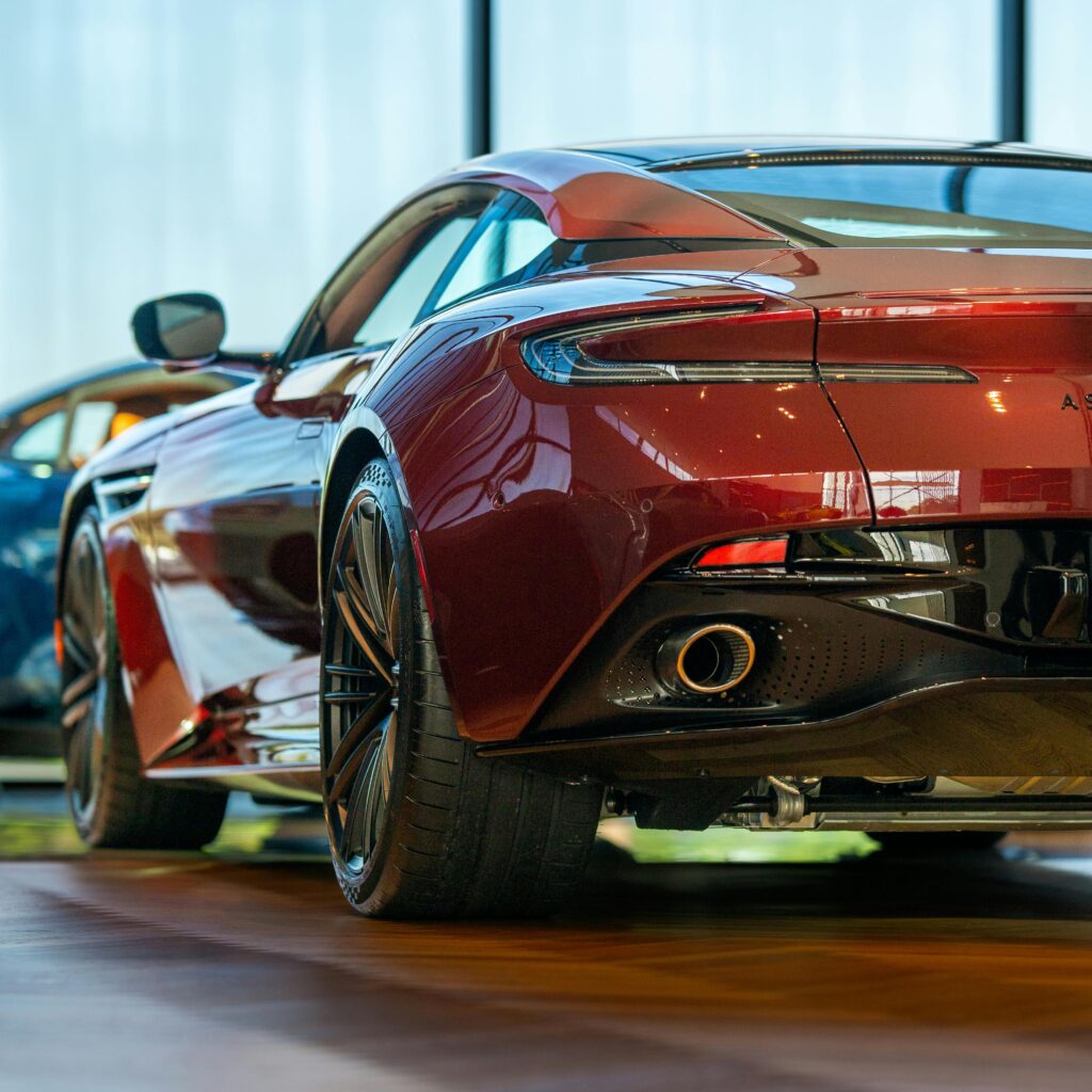 Elegant red sports car showcased in a modern showroom, highlighting its sleek design and luxury features.