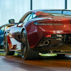 Elegant red sports car showcased in a modern showroom, highlighting its sleek design and luxury features.